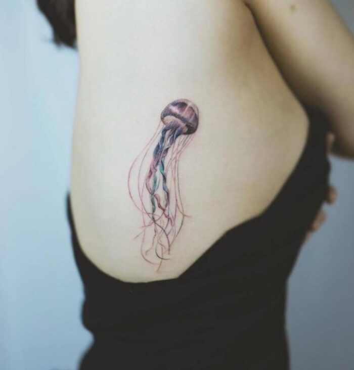 Tatuaje de medusa en costilla minimalista