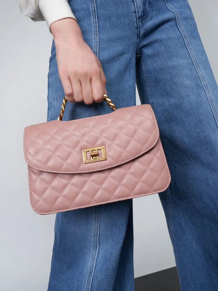 elegante traje de mezclilla vintage y bolso rosa crema