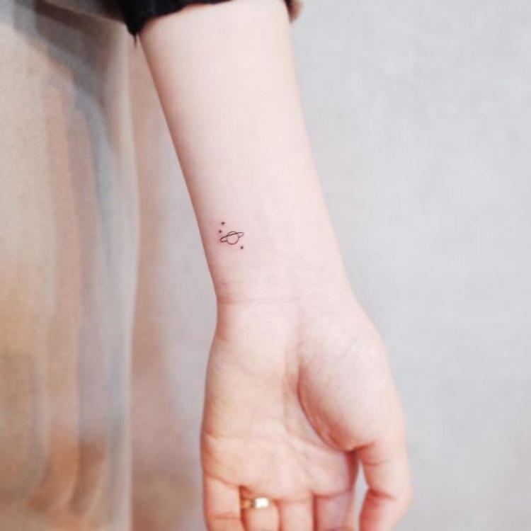 tatuaje-pulso-discreto-planeta-estrellas-estilo-minimalista