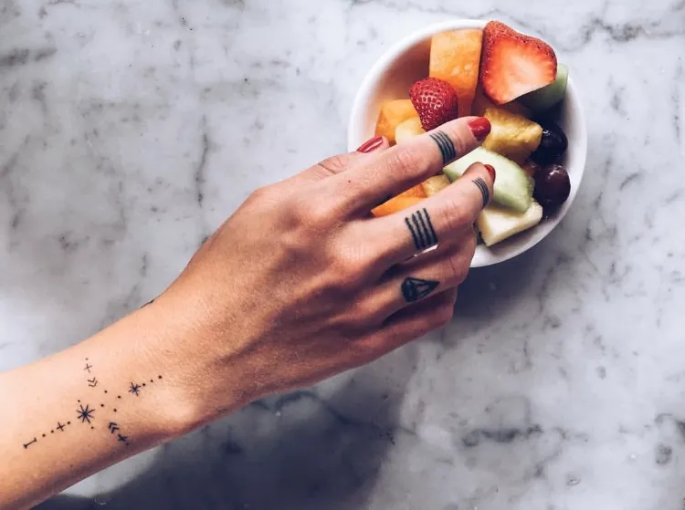 tatuaje de estrella mujer tatuada Caroline Receiveur dedos símbolos de agarre