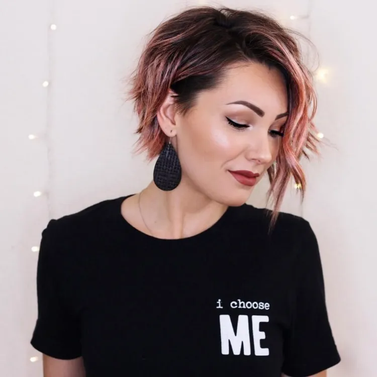 bob asimétrico corto y ondulado con balayage de tonos rosados en cabello castaño
