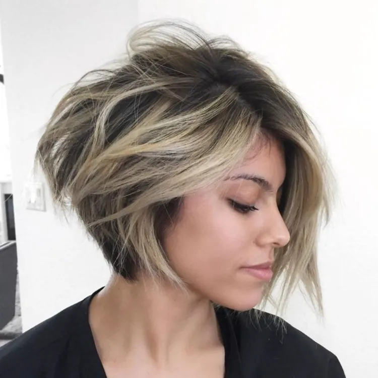 corte cuadrado asimétrico despeinado con tonos rubios en cabello ondulado