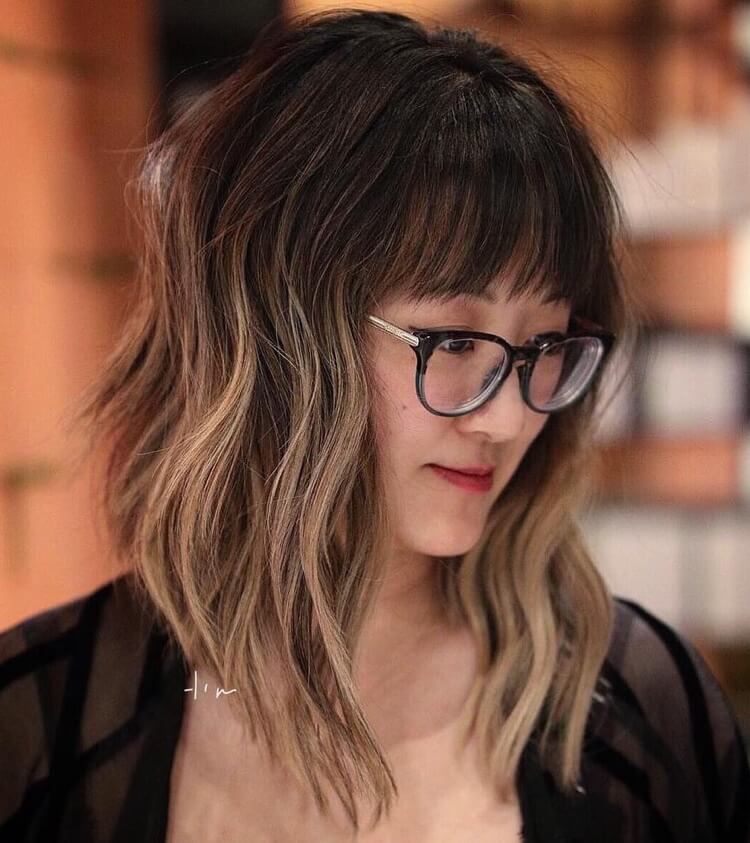 bob ondulado con flequillo recto ombré miel balayage