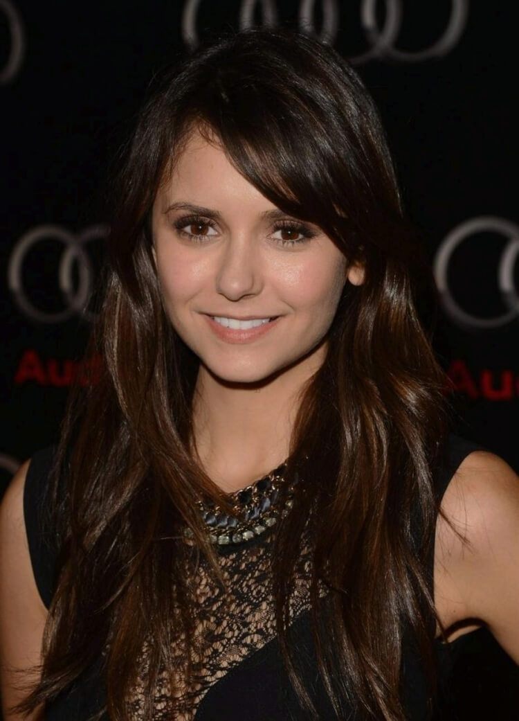 Cabello largo y abundante, peinado con flequillo hacia un lado, Nina Dobrev
