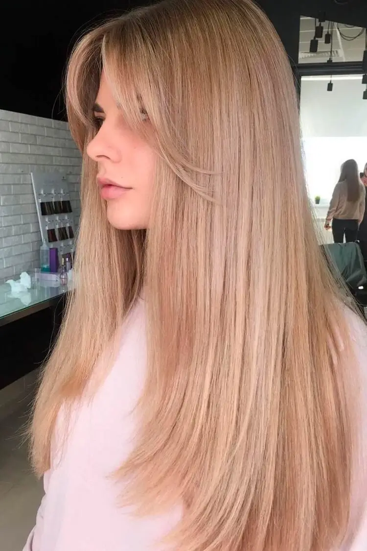 flequillo de cortina en cabello largo y liso coloración rubia fresa