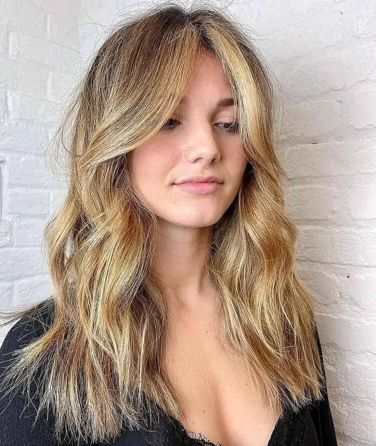 cabello ondulado medio largo con flequillo drapeado para cara ovalada