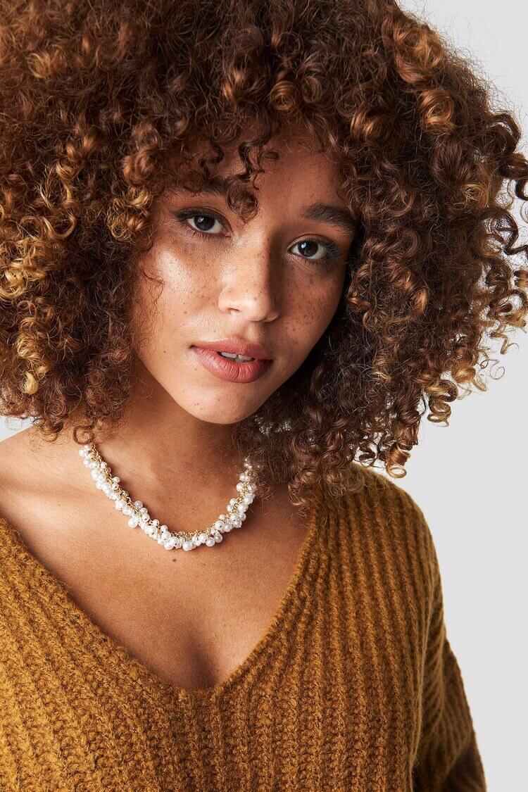 Chica joven con cabello rizado y ondulado de forma natural