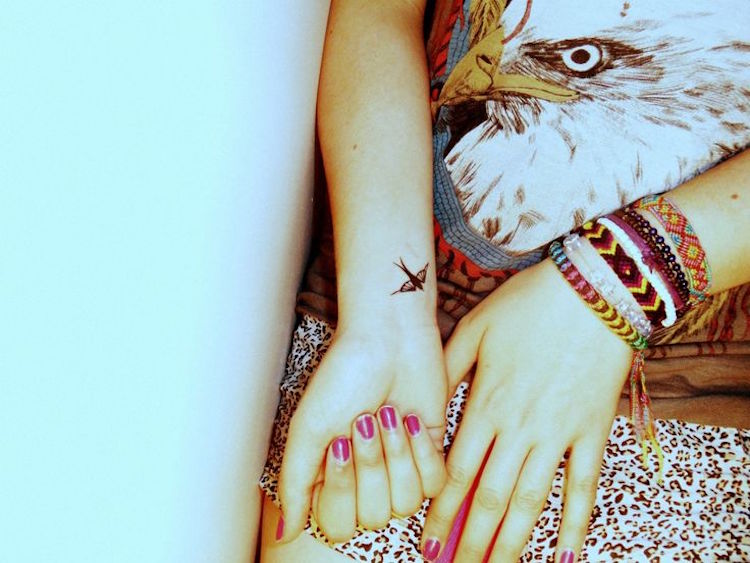 discreto pájaro tatuaje-tatuaje-muñeca-mujer